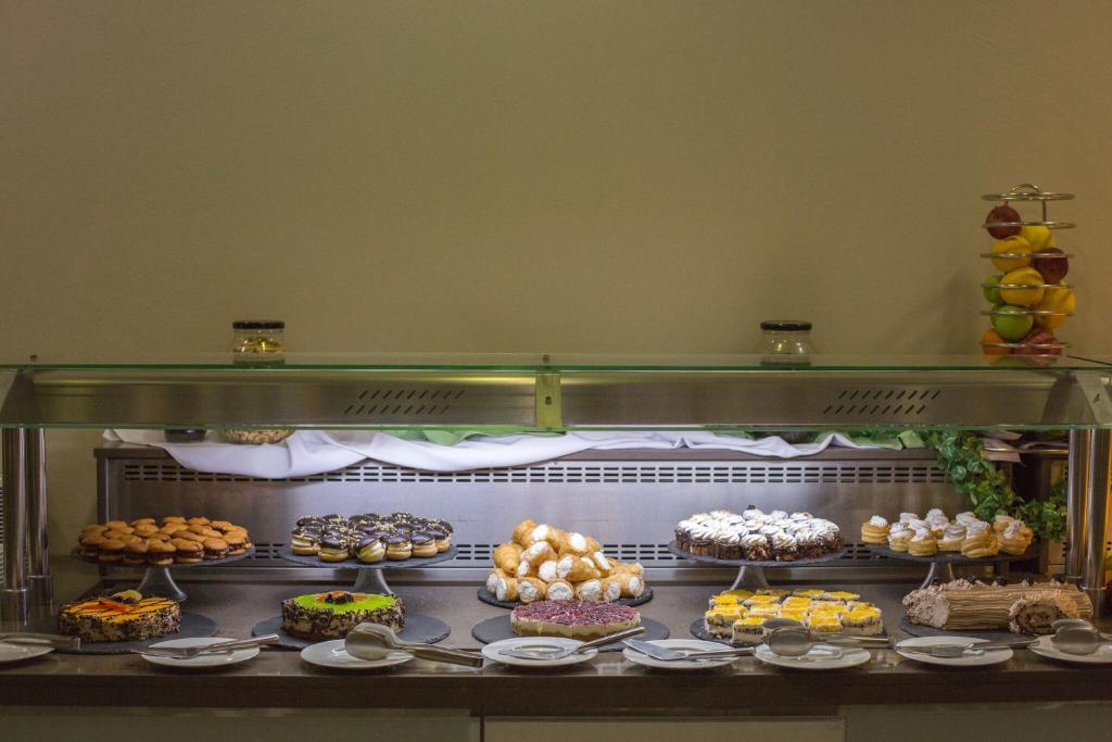 Deserts un kūkas izkārtotas uz bufetes galda, apvienojot dažādus saldumus un augļus. Saldumi ir dažādās formās un krāsās, radot pievilcīgu redzējumu.