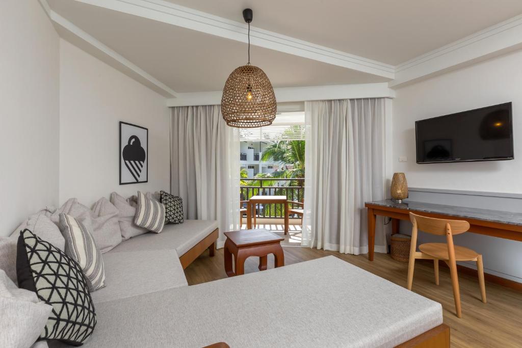 Mūsdienīgs viesnīcas numurs ar ērtu atpūtas zonu, lielu logu un izskatīgu galdu. Interjers ir gaišs un viesmīlīgs, ar dabīgiem materiāliem un dekoratīviem elementiem.