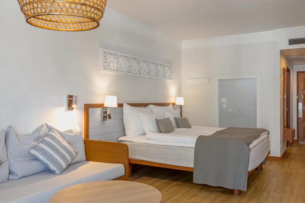 Mūsdienīgs viesnīcas numurs ar divguļamo gultu, komfortablu dīvānu un elegantu apgaismojumu. Interjers ir gaišs un ietilpīgs, radot mājīgu atmosfēru.