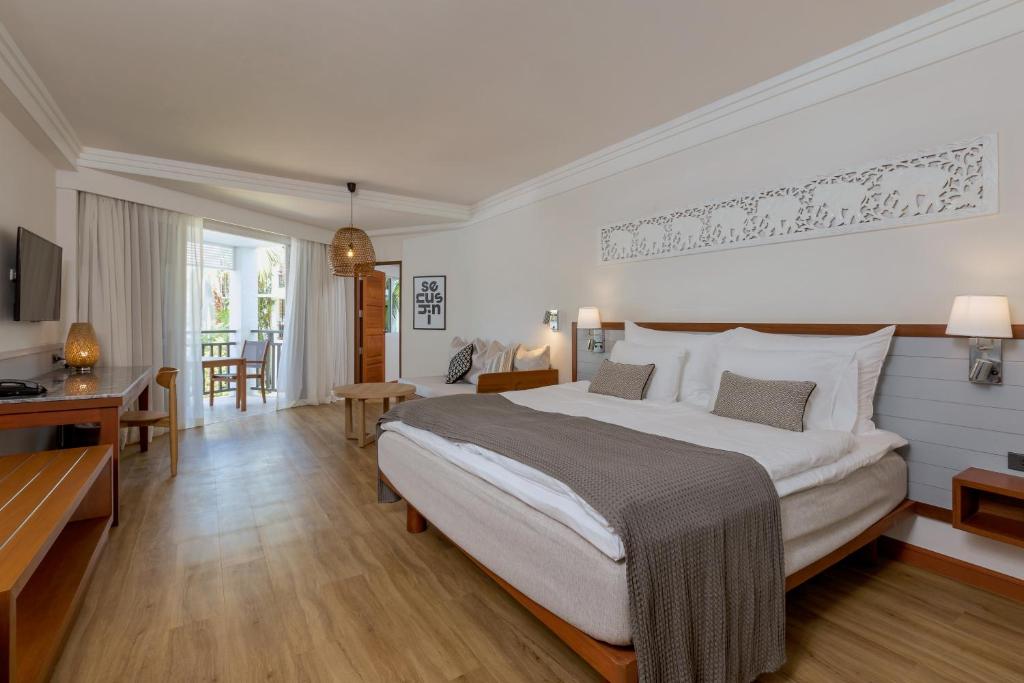 Moderns viesnīcas numurs ar plašu gultu, elegantu dekoru un balkonu, kas piedāvā skatu uz dārzu. Telpā ir koka grīdas un gaiši toņi, kas rada patīkamu atmosfēru.