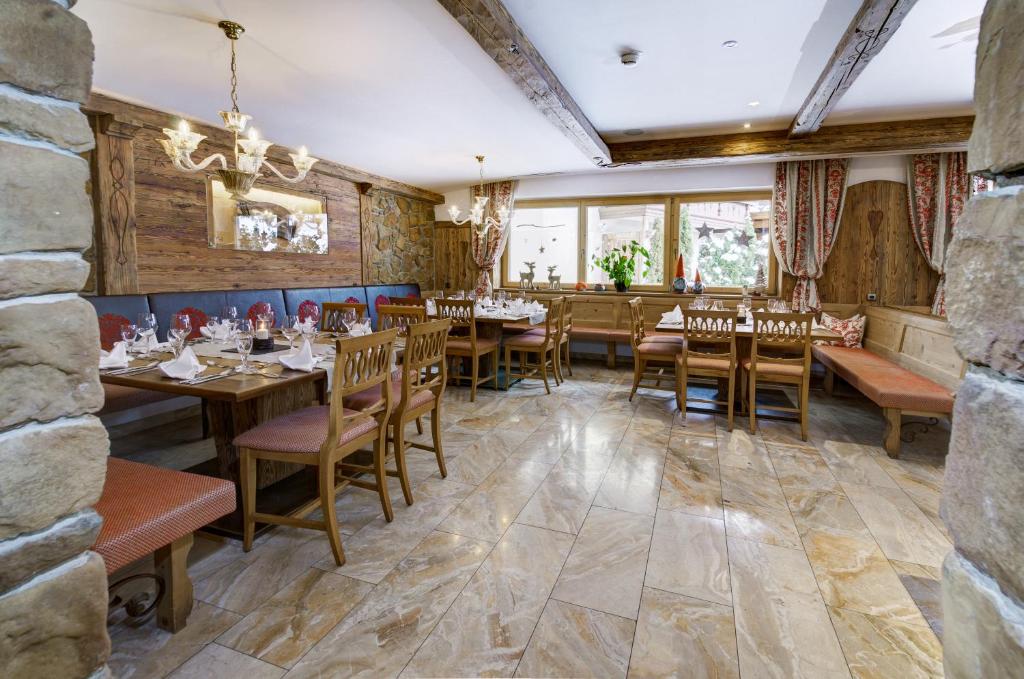 Restorāna interjers ar koka mēbelēm un akmens detaļām, kas rada siltu un mājīgu atmosfēru. Labi noformētas galdi un krēsli, kas gaida viesus.