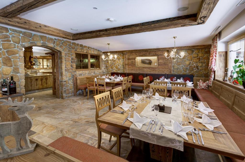 Restorāna interjers ar akmens sienām, koka mēbelēm un eleganti klātiem galdiem. Telpa ir silta un viesmīlīga, piemērota gan ģimenes vakariņām, gan svinībām.