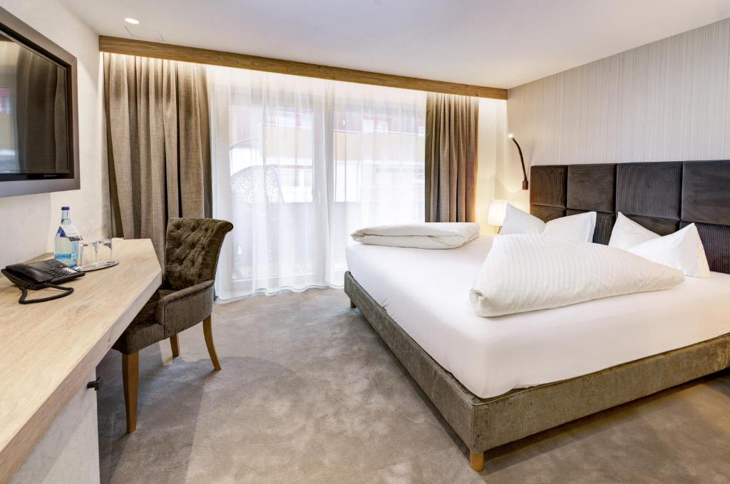 Mūsdienīgs viesnīcas numurs ar ērtu gultu, galdu un krēslu, kā arī lieliem logiem un dabīgu apgaismojumu. Numurs ir elegantā dizainā ar neitrālām krāsām.