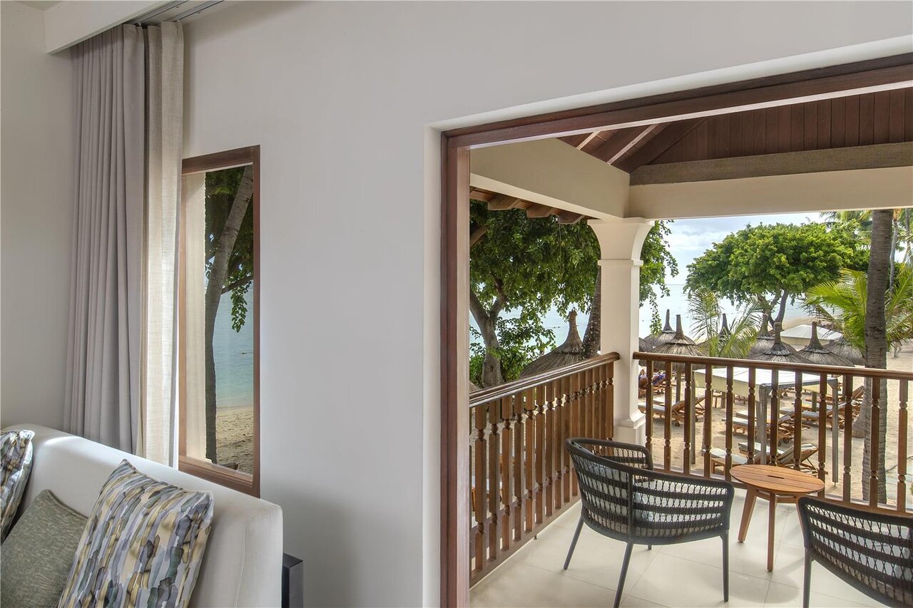 Hilton Mauritius Resort & Spa numurs ar skatu uz pludmali un balkonu.