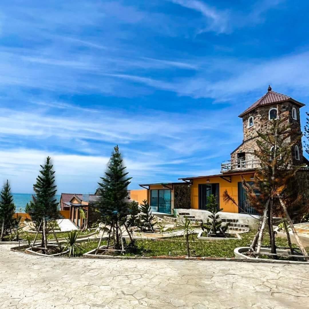 Adora Kega Beach Resort viesnīca piekrastē ar dārzu un torni.