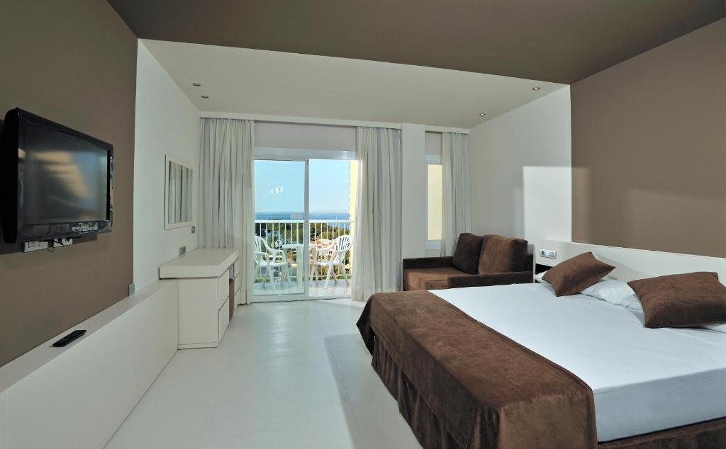 Mūsdienīga viesnīcas numura iekārtojums ar plašu skatu uz jūru, gaisīgu interjeru un ērtiem mēbeļu elementiem. Numurā ir televizors, dīvāns un balkons.