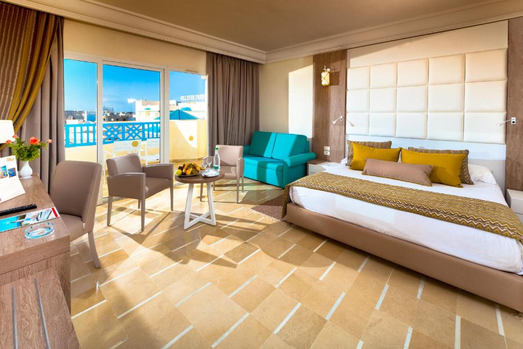 Mūsdienīgs viesnīcas numurs ar plašu logu, kas sniedz gaismu un skatu uz terasi. Interjerā ir ērta gulta ar spilveniem, dīvāns un galdiņš ar augļiem un ūdeni.