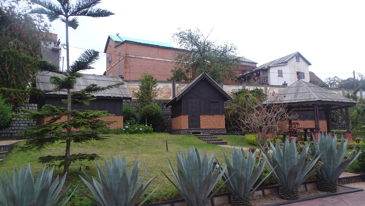 Artisan viesnīcas dārza ainava ar tradicionālām būdām.