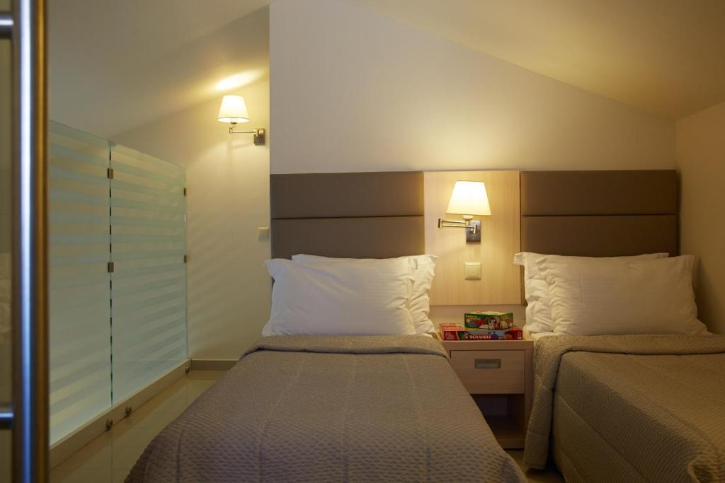 Mūsdienīga viesnīcas istaba ar divām vienguļamām gultām, gaismas ķermeņiem un modernu interjeru. Ideāla vieta atpūtai un relaksācijai.