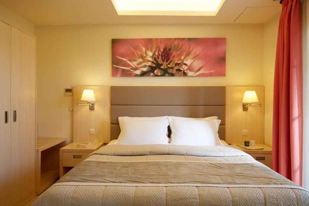 Mūsdienīgs viesnīcas numurs ar ērtu gultu, koka mēbelēm un dekoratīvu attēlu uz sienas. Gaisma un silti toņi rada mājīgu atmosfēru.