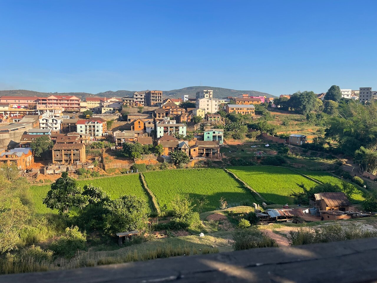 Pilsētas panorāma ar lauku un kalniem fonā