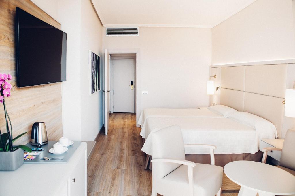 Arona Gran Hotel & Spa moderns numurs ar divguļamo gultu un televizoru.