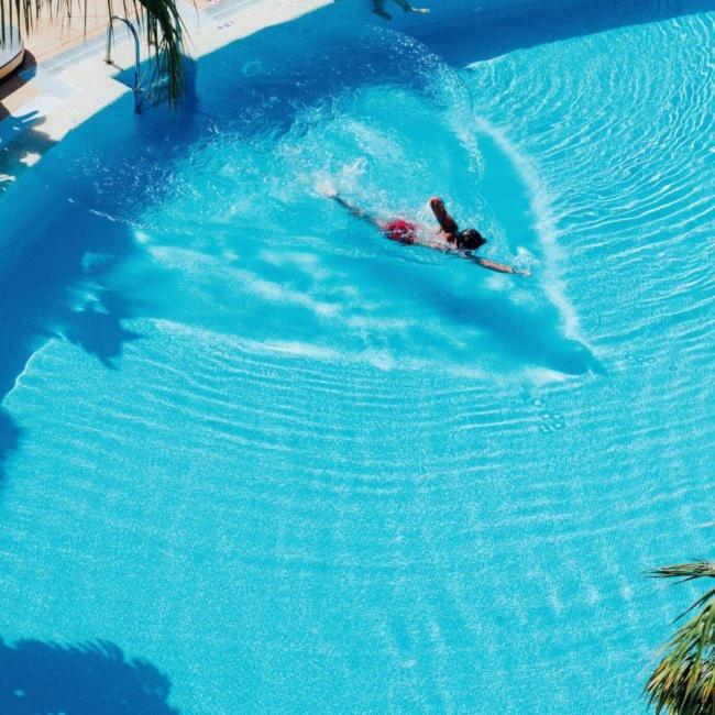 Arona Gran Hotel & Spa baseins ar peldētāju.