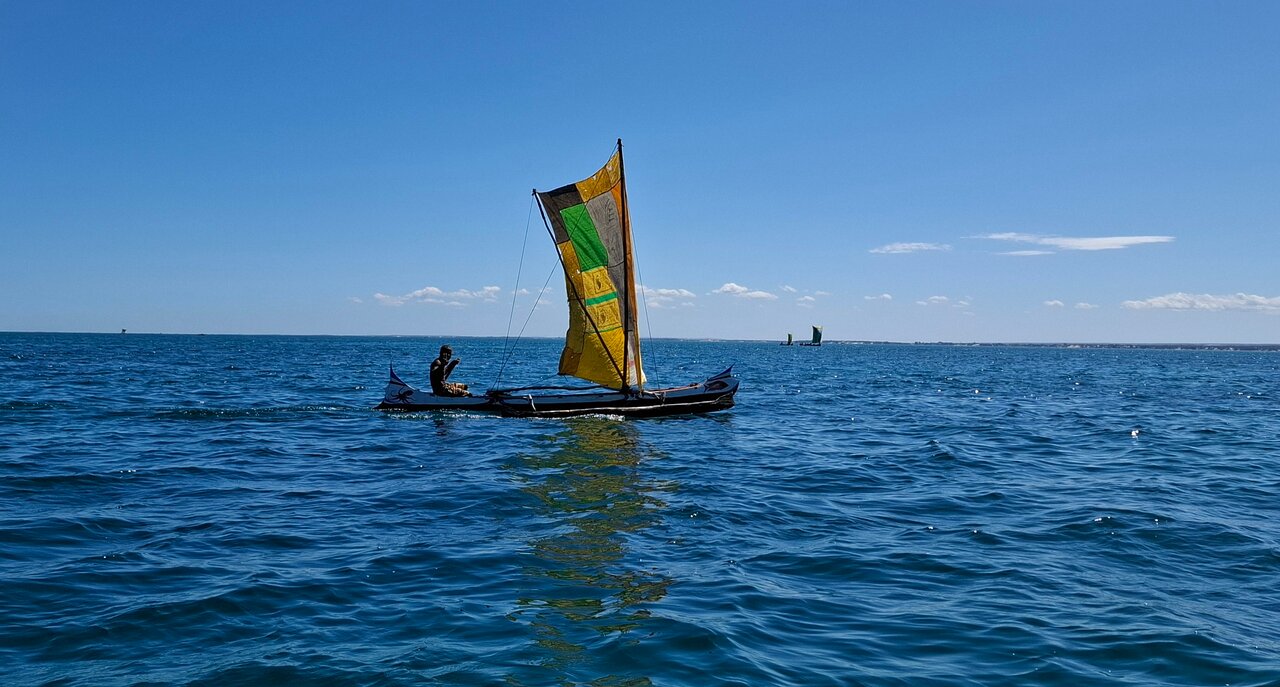 Vīrs uz laivas ar burām pie La Mira de Madiorano krasta.