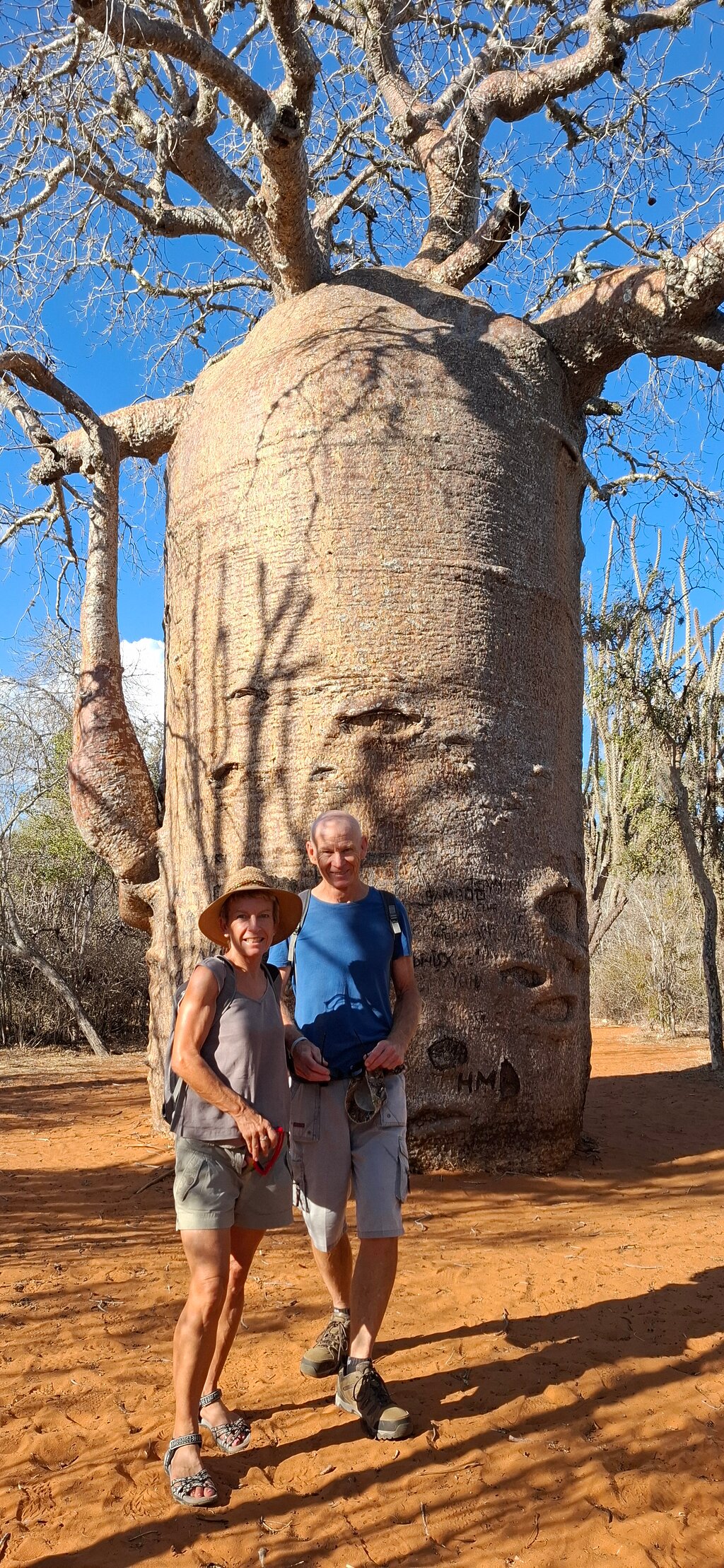 Divi cilvēki pie baobaba koka Madagaskarā.