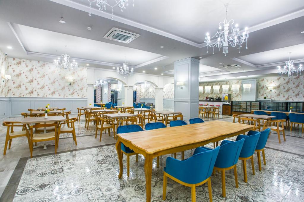 Moderns restorāns ar gaišu interjeru, koka galdiem un ziliem krēsliem, dekorēts ar ziedu motīviem un elegantiem lustriem. Ideāla vieta ēdienu baudīšanai un socializēšanai.