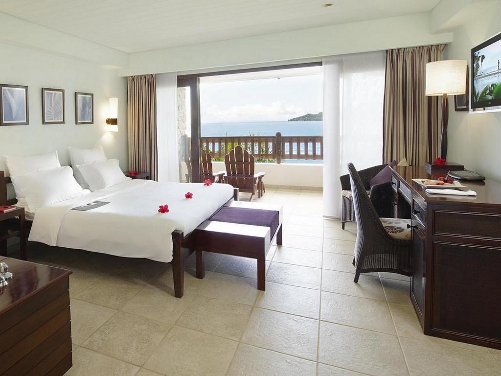 Mūsdienīgs viesnīcas numurs ar skatu uz jūru, ietverot divguļamo gultu, rakstāmgaldu un relaksācijas zonu. Telpā ir gaiši toņi un dekoratīvi elementi, kas rada patīkamu atmosfēru.