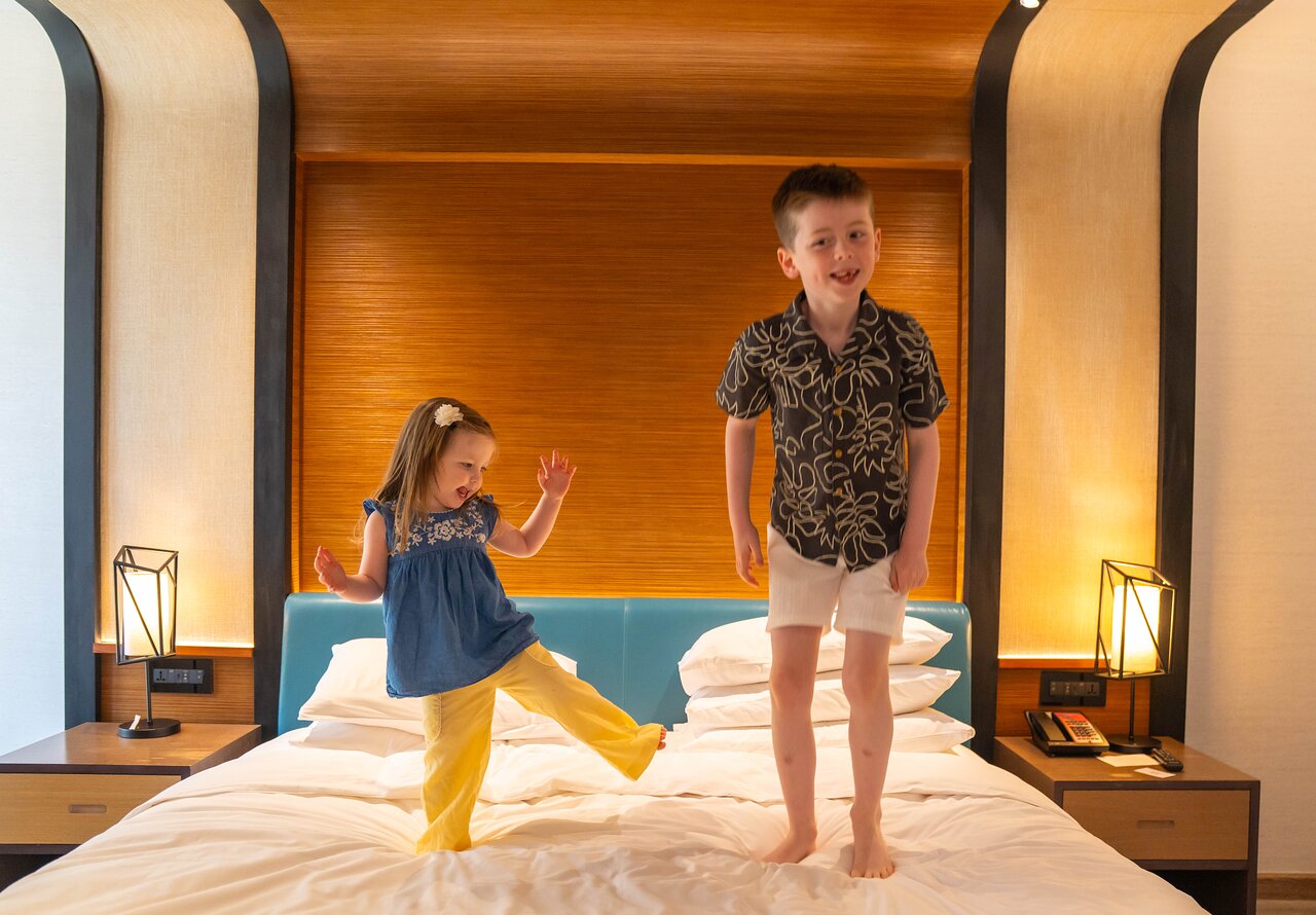 Bērni lēkā uz gultas Andaz Dubai The Palm numurā.