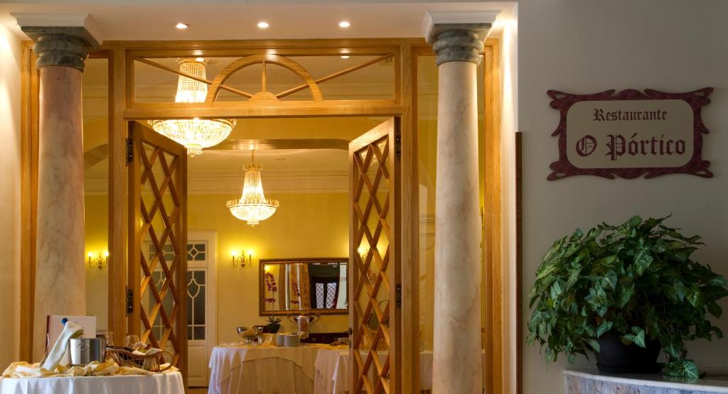Elegants restorāna "O Pórtico" ieeja ar koka durvīm un greznām lampām, kas rada siltu un aicinošu atmosfēru. Sākuma punkts gardām maltītēm un izsmalcinātai apkalpošanai.