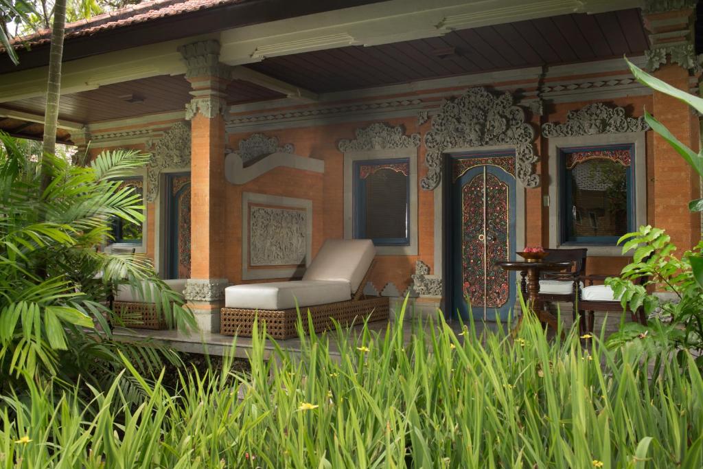 Bali stilā māja ar grezniem durvīm un terasi, apjozta ar zaļumu un tropiskām augiem. Ideāla vieta atpūtai un relaksācijai.