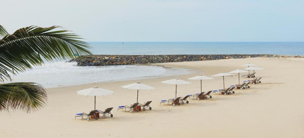 Baltas pludmales ar zvilņiem pie The Cliff Resort & Residences piekrastes.