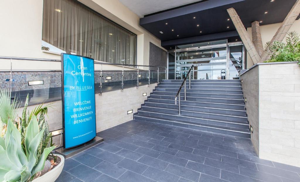 Ieejas zona viesnīcā Gran Cervantes by Bluesea ar modernu arhitektūru un viesmīlīgu atmosfēru, uzsverot daudzvalodīgu sveicienu.