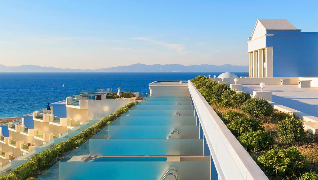 Mūsdienīgas viesnīcas skats ar baseiniem un jūras ainavu, kas papildina relaksējošu atmosfēru. Ideāli piemērota atpūtai un brīvdienām.