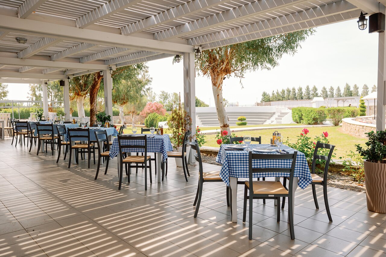 Āra terase ar zilu rūtainu galdautu restorānā Kiotari Miraluna Resort