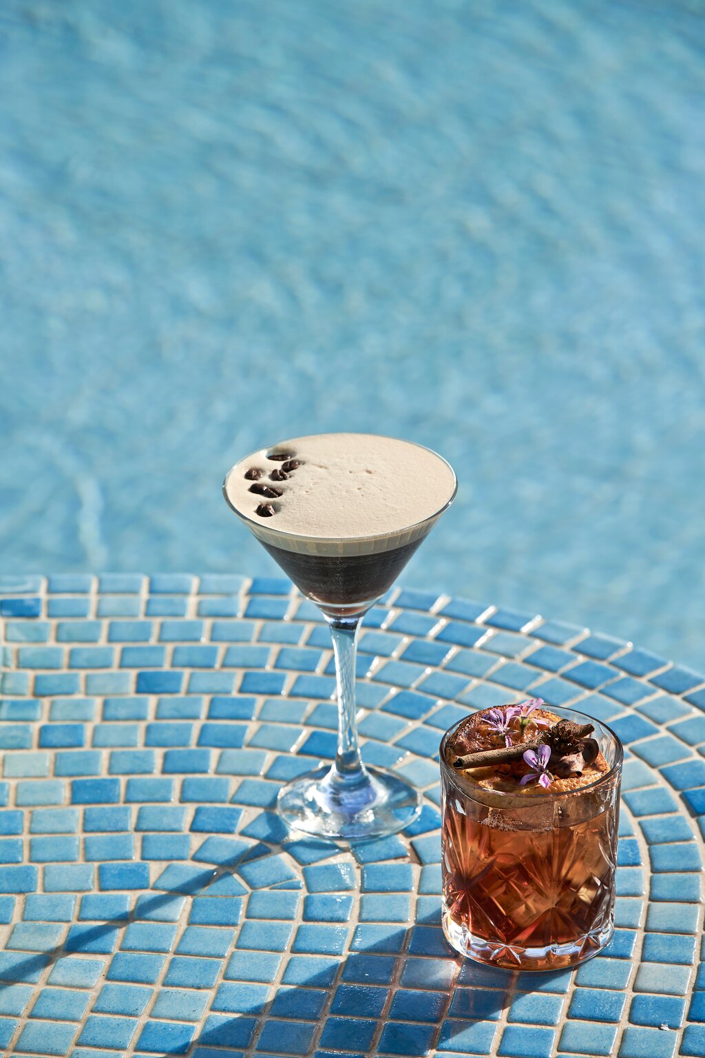 Divi kokteiļi uz flīzēta galdiņa pie baseina Kiotari Miraluna Resort.