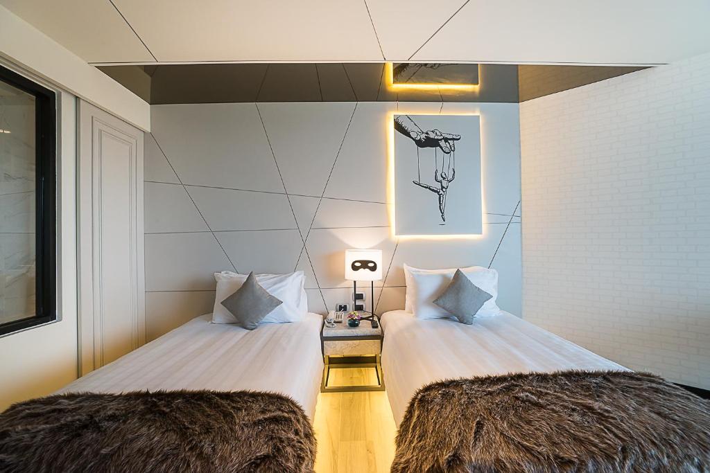 Mūsdienīgs viesnīcas numurs ar divām atsevišķām gultām, stilīgu apgaismojumu un unikālu mākslas darbu uz sienas. Numurā ir eleganti interjera elementi un komfortabli aksesuāri.