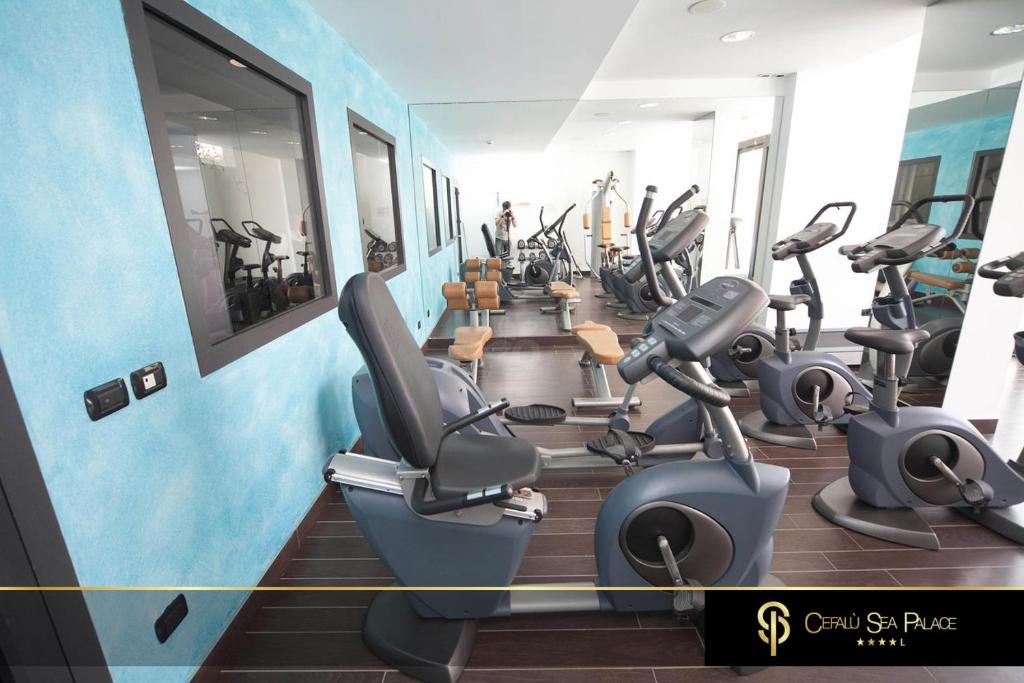 Mūsdienīgs trenažieru zāles interjers ar zilu sienu un dažādiem trenažieriem. Gaismas un spoguļu klātbūtne rada patīkamu atmosfēru sportošanai.