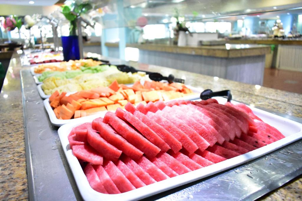 Dažādu svaigu augļu bufete ar ūdensmelnēm, cantaloupe un ananāsiem, izvietota uz galda.