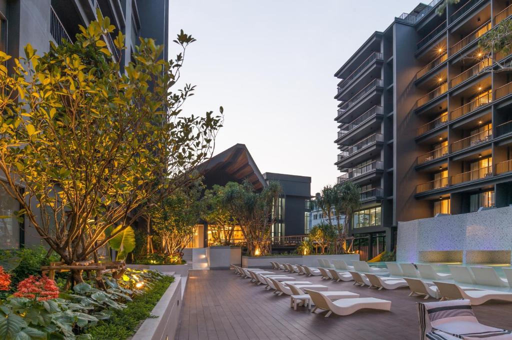 Panan Krabi Resort baseins ar saulainām gultām un zaļiem augiem.