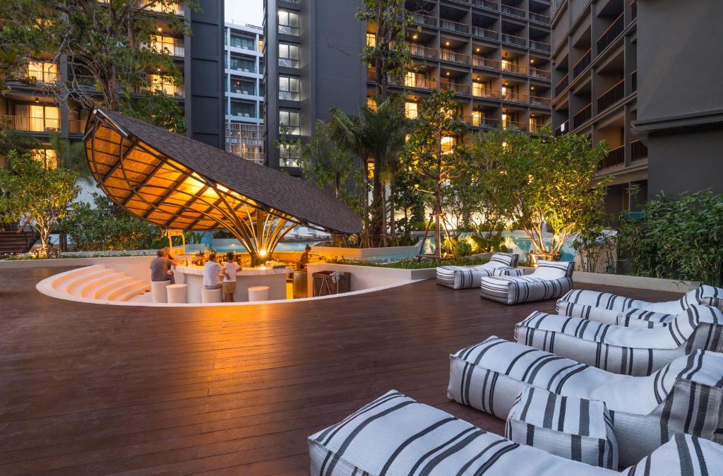 Panan Krabi Resort bārs ar mūsdienīgu jumtu un atpūtas zonu pie baseina.