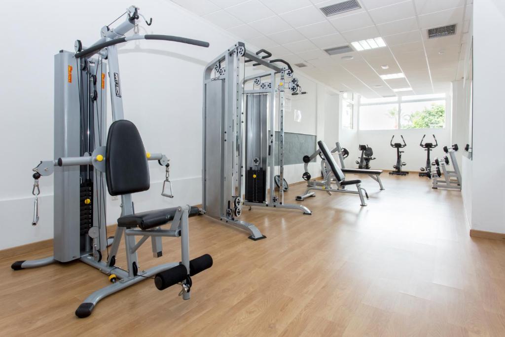 Mūsdienīgs sporta zāles iekārtojums ar dažādām trenažieriem un apgaismojumu, kas nodrošina patīkamu vidi treniņiem. 