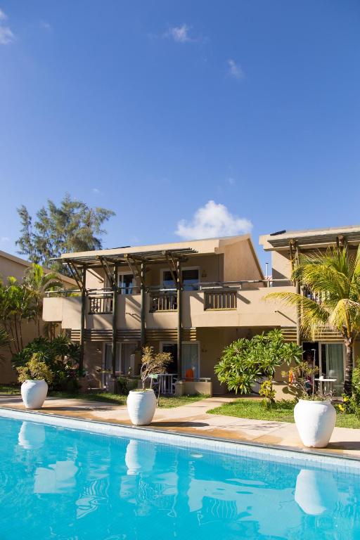 Sauļota viesnīca ar baseinu un zaļām terasēm, apstādījumus rotā ziedi un palmas. Ideāla vieta atpūtai un relaksācijai.