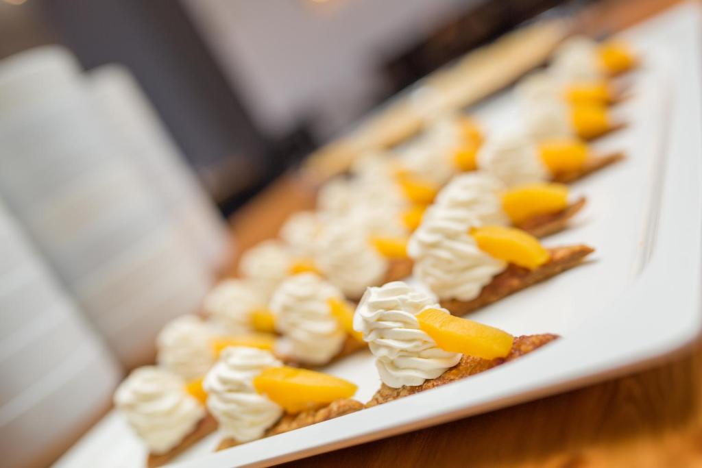 Deserts ar krējuma virskārtu un persiku gabaliņiem uz cepumu bāzes.