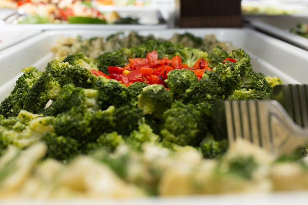 Krāšņs brokoļu un sarkano papriku salātu ēdiens, kas izkārtots uz galda. Šī veselīgā uzkoda ir ideāla izvēle gardēžiem.