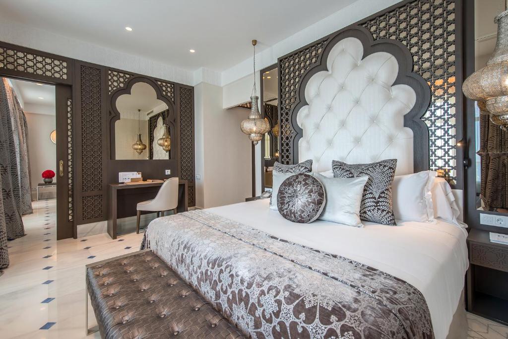 Luksusa viesnīcas numurs ar mūsdienīgu arābu stila interjeru, ieskaitot greznas gultas, dekoratīvas spilvenus un elegantu apgaismojumu. Numurā ir arī darba galds un komfortabla sēdvieta.