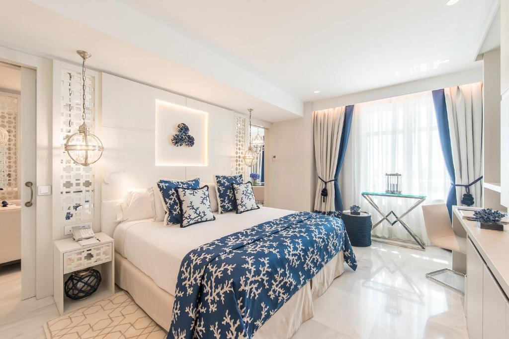 Mūsdienīgs viesnīcas numurs ar baltām un zilo akcentiem, iekārtots ar elegantu mēbelējumu un gaismas elementiem, kas rada patīkamu atmosfēru. Guļamistabā ir ērta gulta un stilīgas dekorācijas.