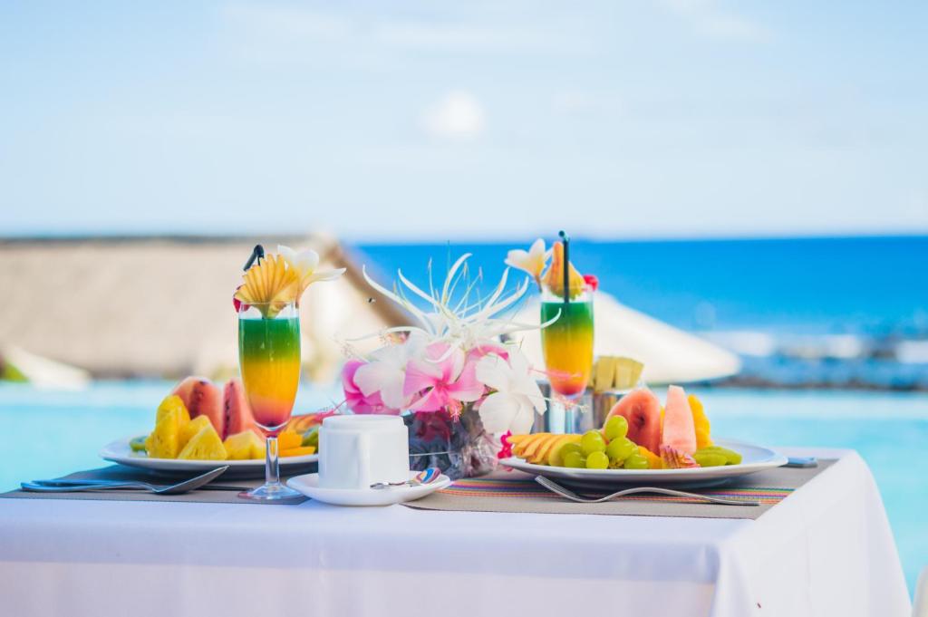 Galda klāšana ar sulīgiem augļiem un krāsainiem kokteiļiem, baudot skaistu skatu uz jūru. Ideāla brīvdienu atmosfēra.
