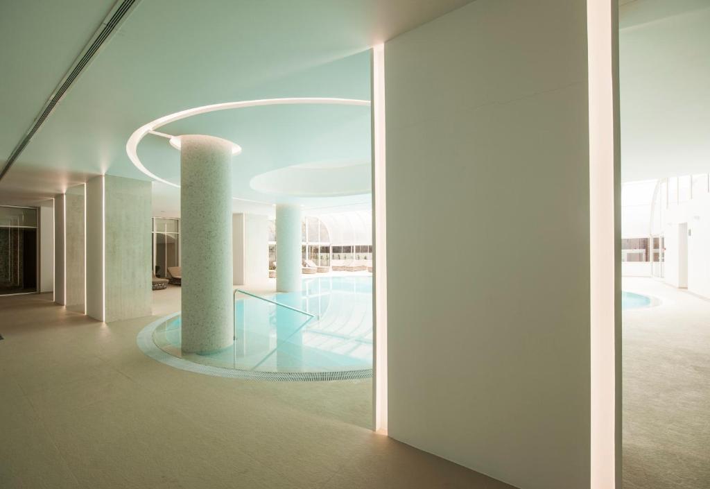 Mūsdienīgs peldbaseins ar minimālistisku interjeru, apgaismots ar siltām gaismām un gludām līnijām. Teritorija ir plaša un gaiša, radot relaksējošu atmosfēru.