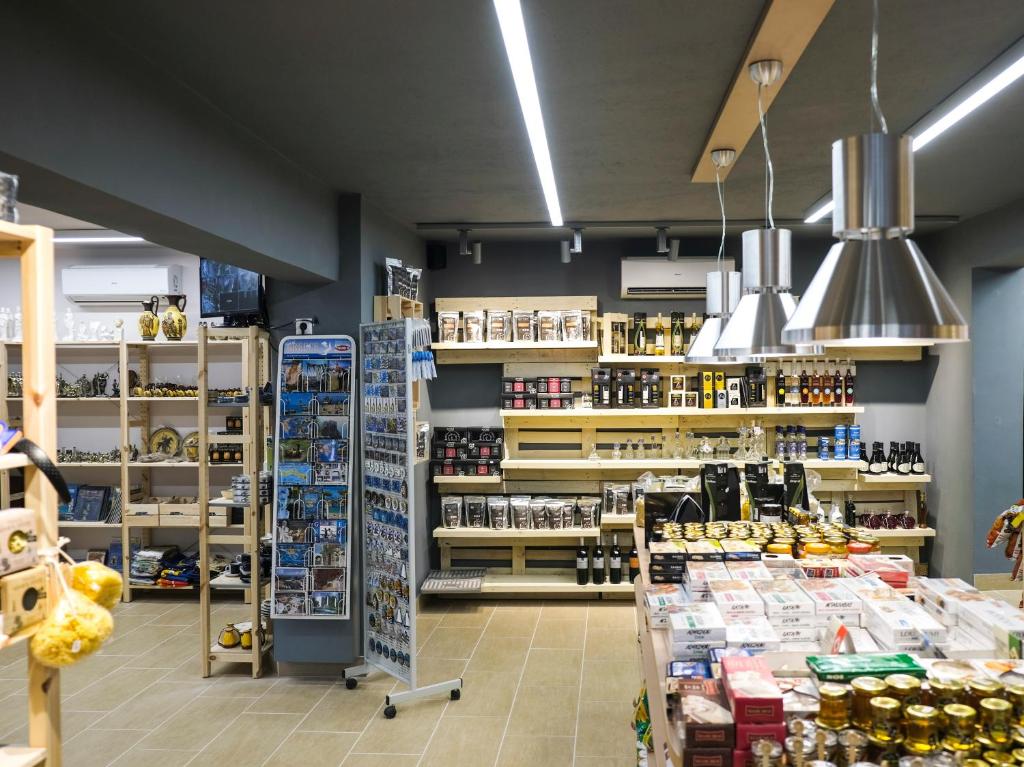 Mūsdienīgs veikals ar plašu preču klāstu, tostarp pārtikas produktiem, suvenīriem un dzērieniem, izvietots uz koka plauktiem. Interjers ir gaišs un sakopts, ar mūsdienīgu apgaismojumu.