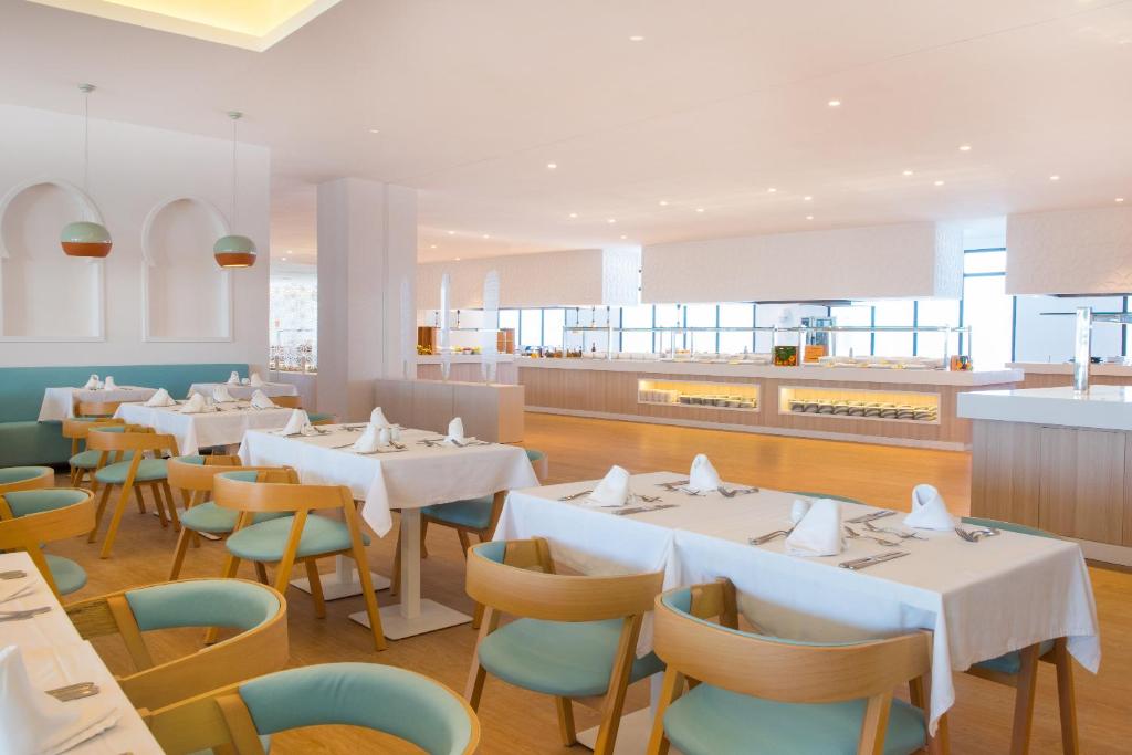 Mūsdienīgs restorāns ar gaišu interjeru un elegantiem galdiem, kas klāti ar baltām galdautiem. Gaismas piekari un plaša bufete rada patīkamu atmosfēru.