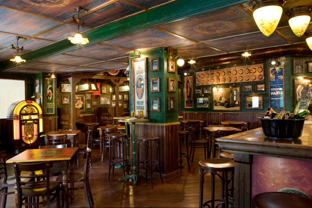 Vēsturiska kroga interjers ar klasiskām mēbelēm, dekoratīviem plakātiem un jukebox, radot mājīgu un autentisku atmosfēru.