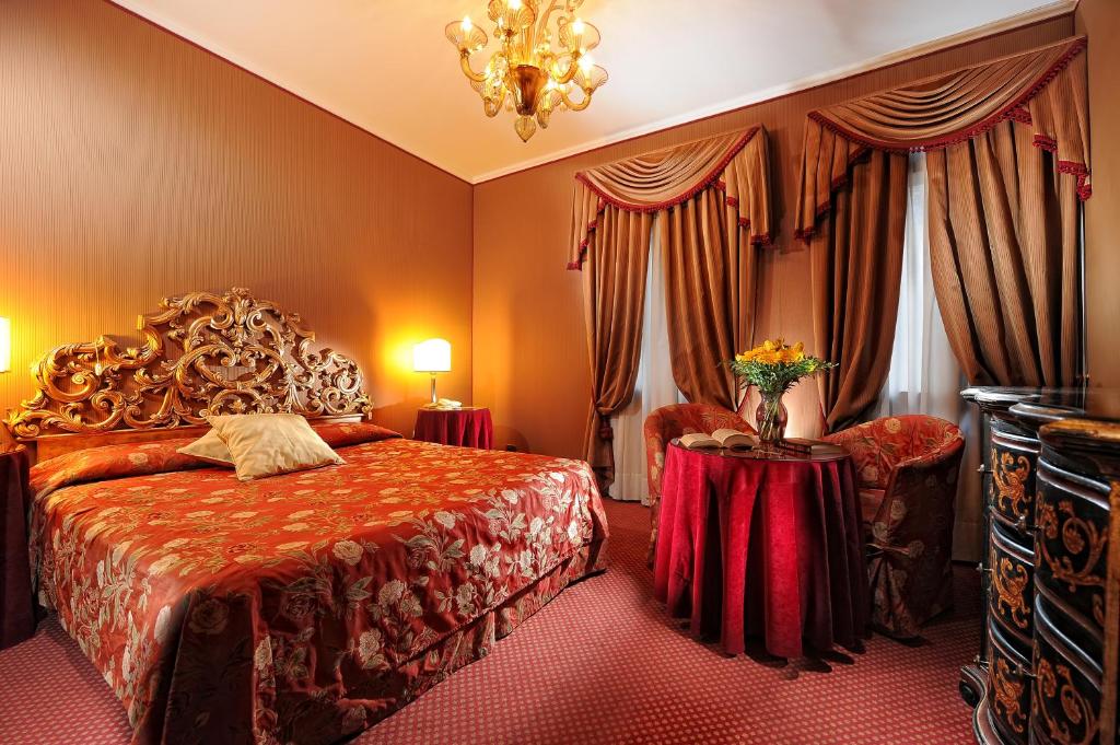 Elegants viesnīcas numurs ar greznu gultu un siltu apgaismojumu, papildināts ar bagātīgiem aizkariem un stilīgu mēbeļu dizainu. Ideāla vieta relaksācijai un komfortam.
