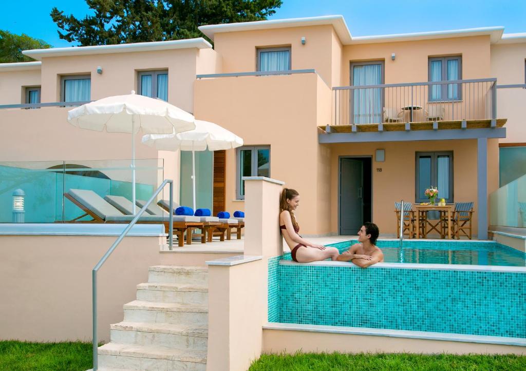 Vasaras brīvdienu atmosfēra pie privāta baseina, kur pāris atpūšas un bauda sauli, kamēr apkārt ir moderns villas dizains un ērtas atpūtas zonas.