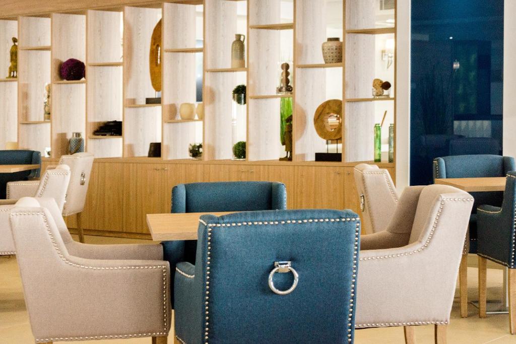 Mūsdienīgs interjers ar komfortablām krēslām un stilīgu plauktu sistēmu, kas izceļ dekoratīvos elementus. Ideāla vieta relaksācijai un sociālajām sanākšanām.