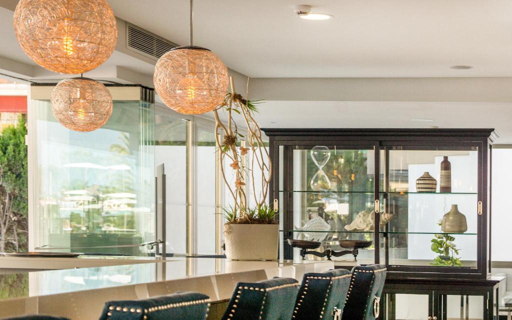 Mūsdienīgs interjers ar rotājošām gaismām un elegantu vitrīnu, kas satur dekoratīvus elementus un augus. Izsmalcināta atmosfēra, kas piemērota relaksācijai un sociālām aktivitātēm.