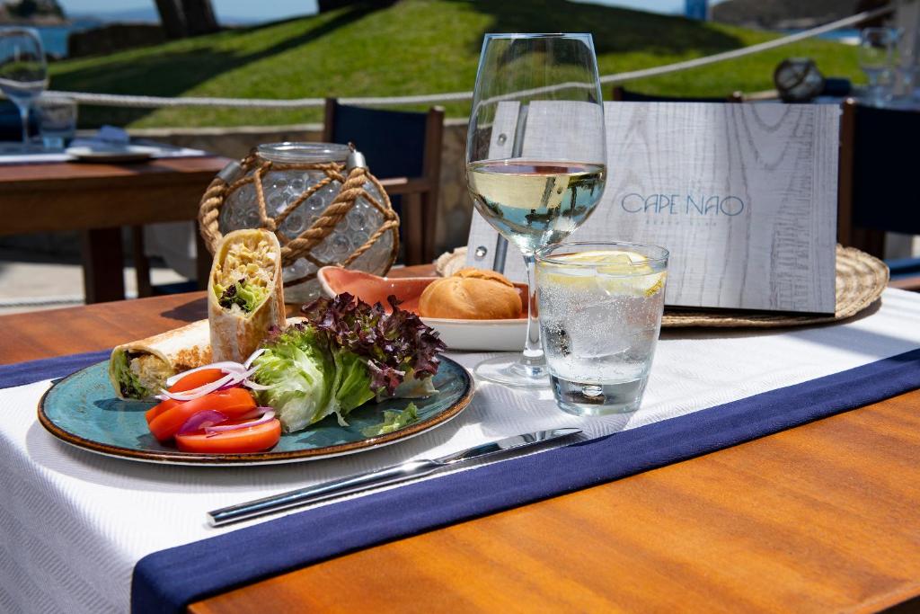 Svaiga maltīte ar tortilju, salātiem un dzērieniem, kas pasniegta pie galda blakus restorāna ēdienkartei.